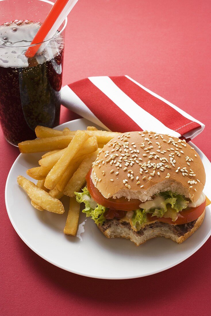 Cheeseburger, angebissen, mit Pommes frites und Cola