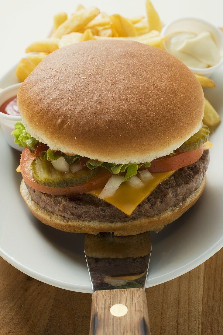 Cheeseburger mit Beilagen auf Teller