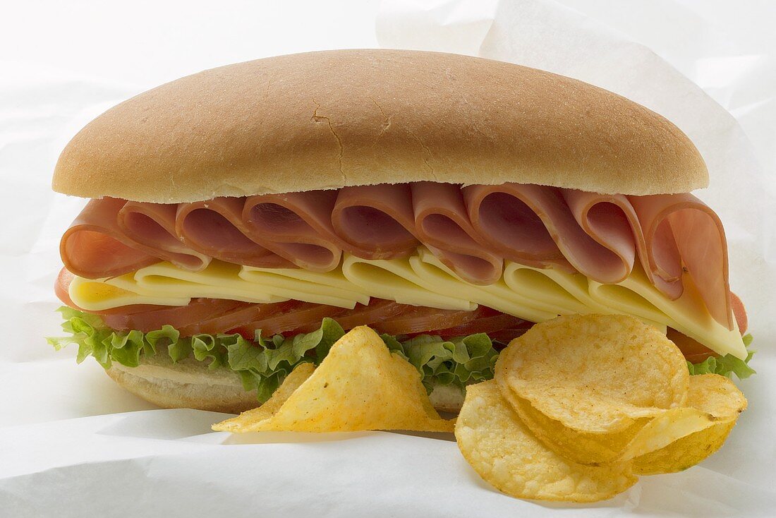 Sub-Sandwich und Chips auf Butterbrotpapier