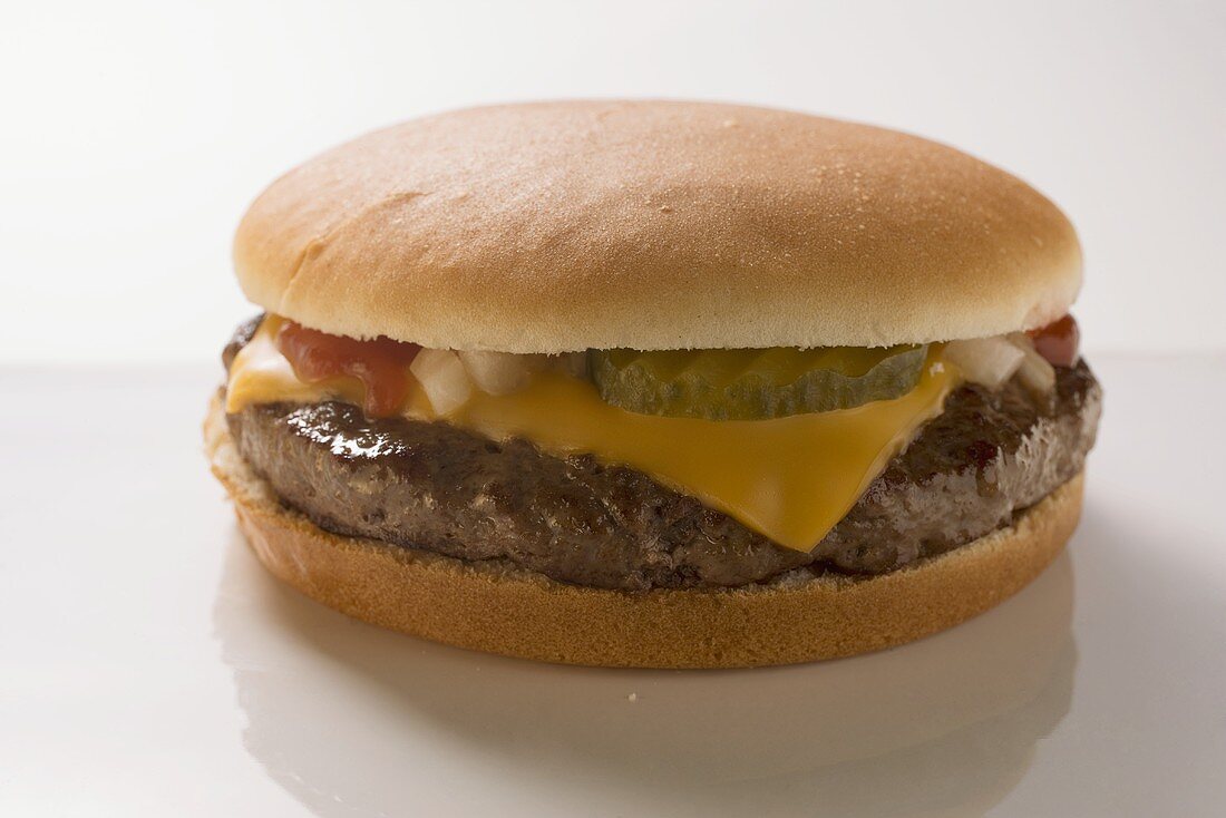 Cheeseburger mit Essiggurke, Zwiebeln und Ketchup