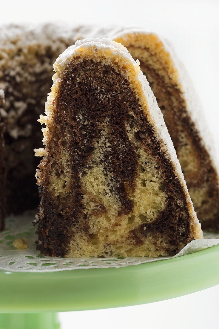 Marbled gugelhupf with icing sugar, a piece cut