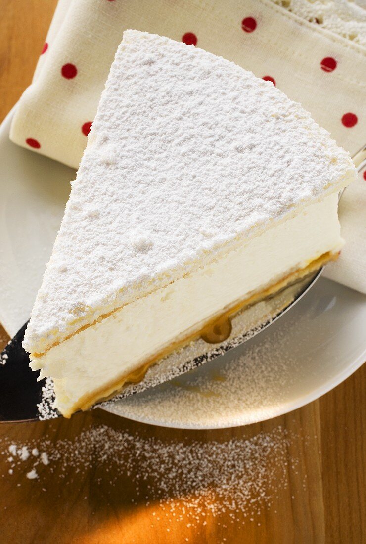 Piece of cream cheesecake on cake slice