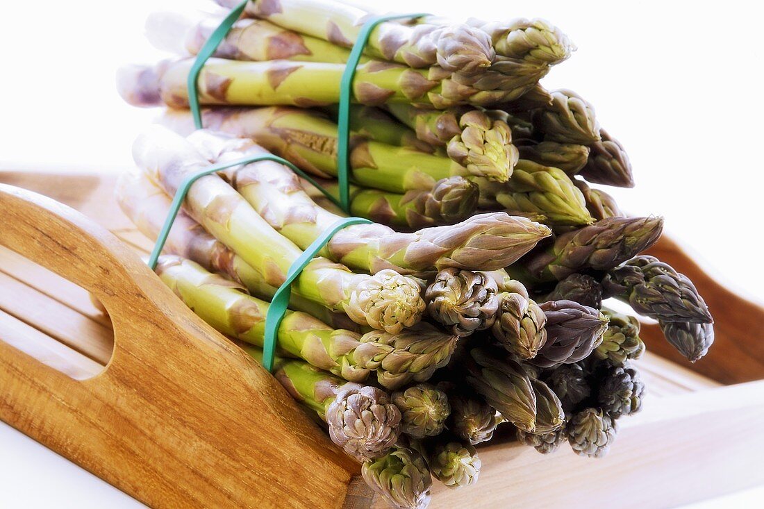 Bundles of green asparagus on wooden table