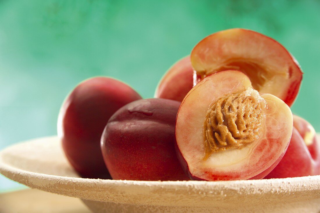 Peaches, one halved, on plate