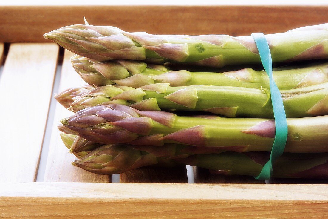 Grüner Spargel, gebündelt, in Steige