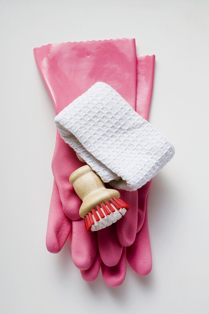 Pink rubber gloves, brush and tea towel