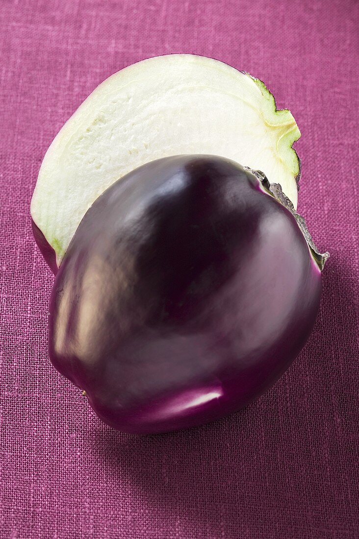 Aubergine, halved, on purple background