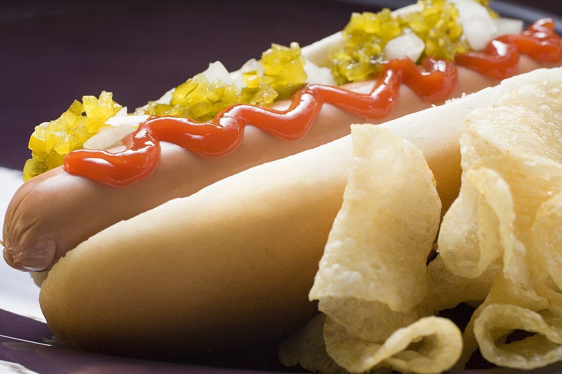 Hot dog with relish, ketchup, onions and crisps