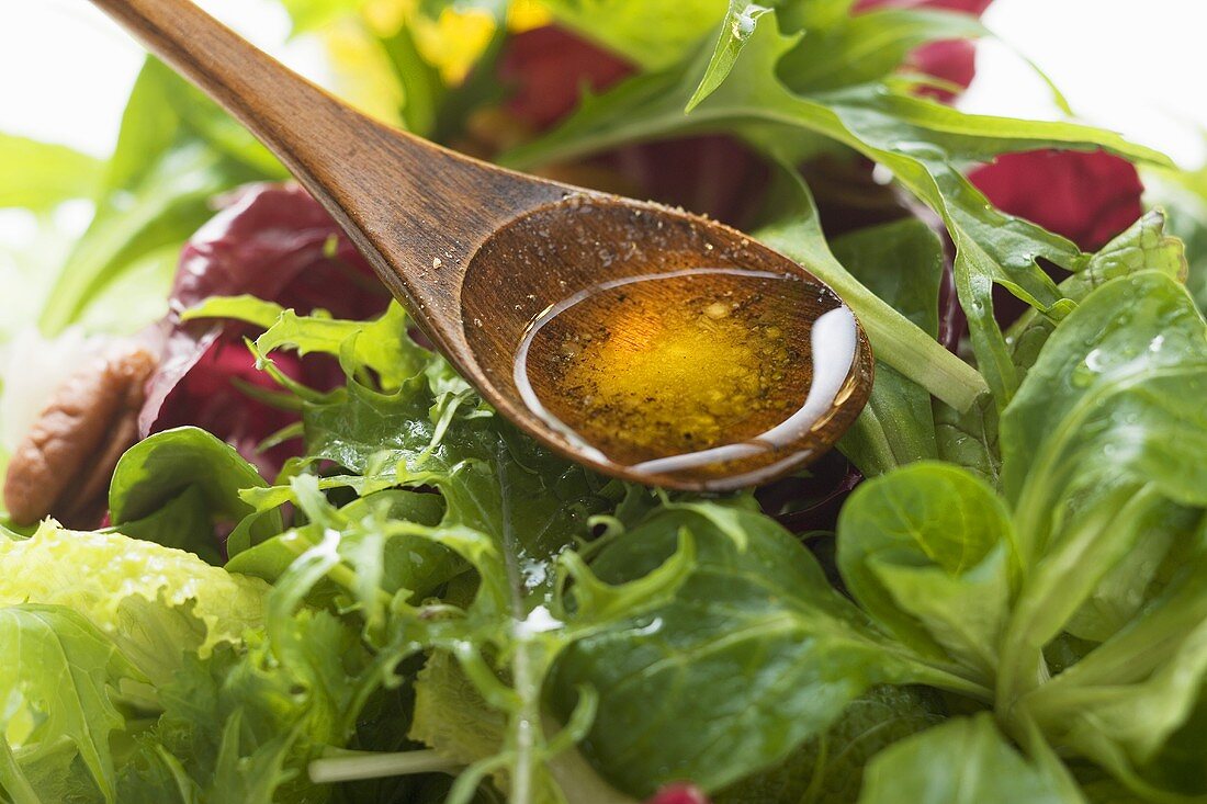 Olivenöl auf Kochlöffel über Blattsalat