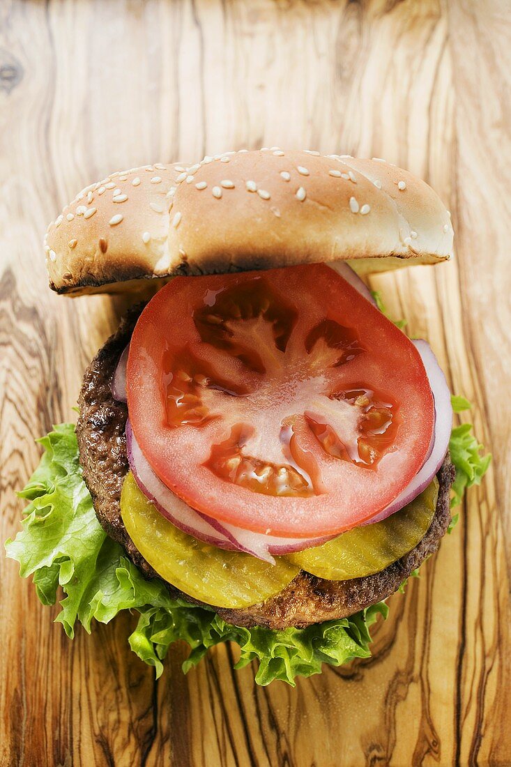Home-made hamburger with gherkins, onions, tomato