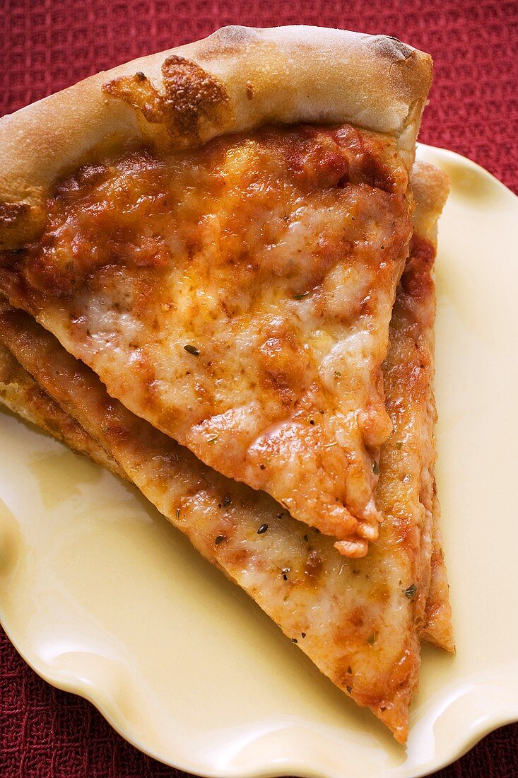 Drei Stücke Pizza Margerita auf gelbem Teller
