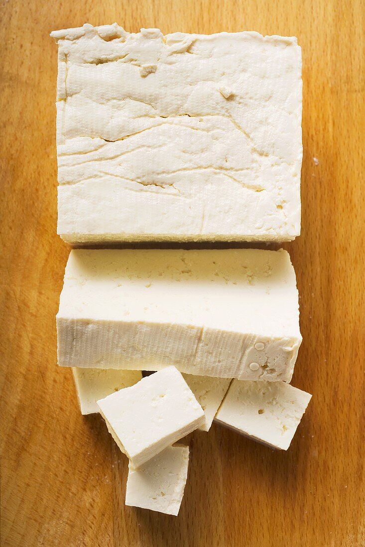 Tofublock, Tofuscheibe und Tofuwürfel auf Holzuntergrund
