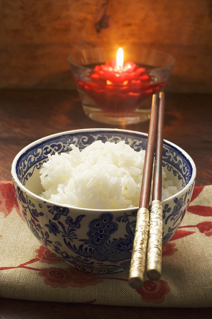 Bowl of rice in front of floating candle (Asia)