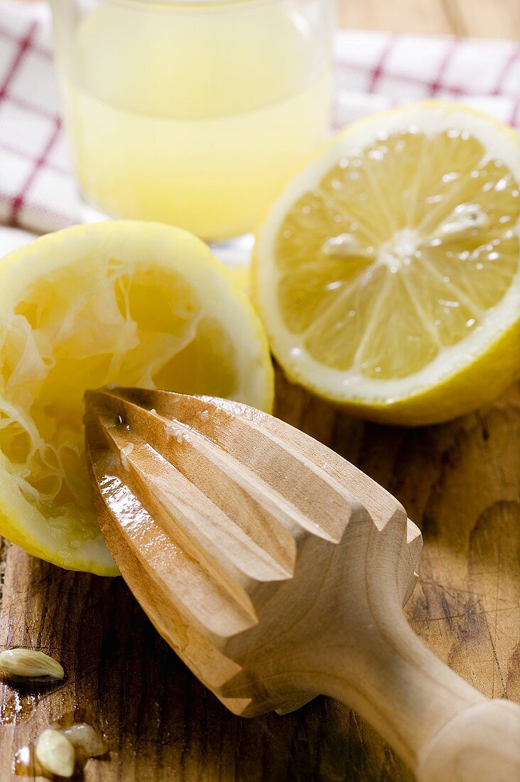 Zitronen mit Holzpresse und Zitronensaft
