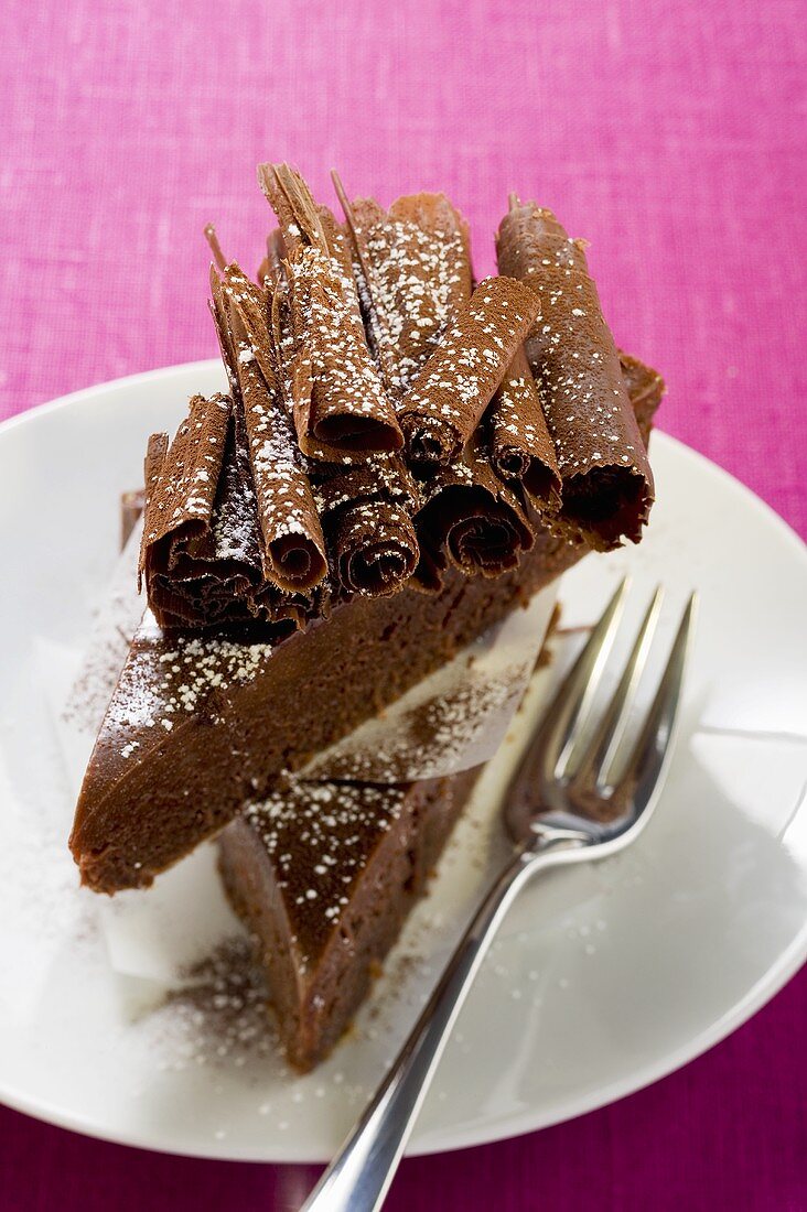 Two pieces of chocolate cake with chocolate curls