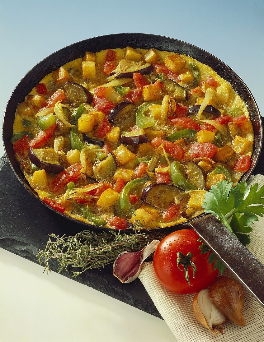 Tortilla with vegetables in frying pan