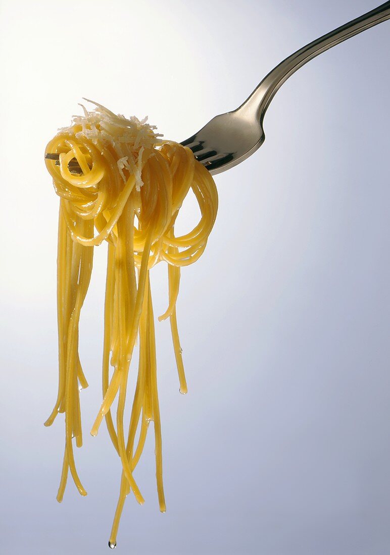 Spaghetti aglio e olio with Parmesan on fork