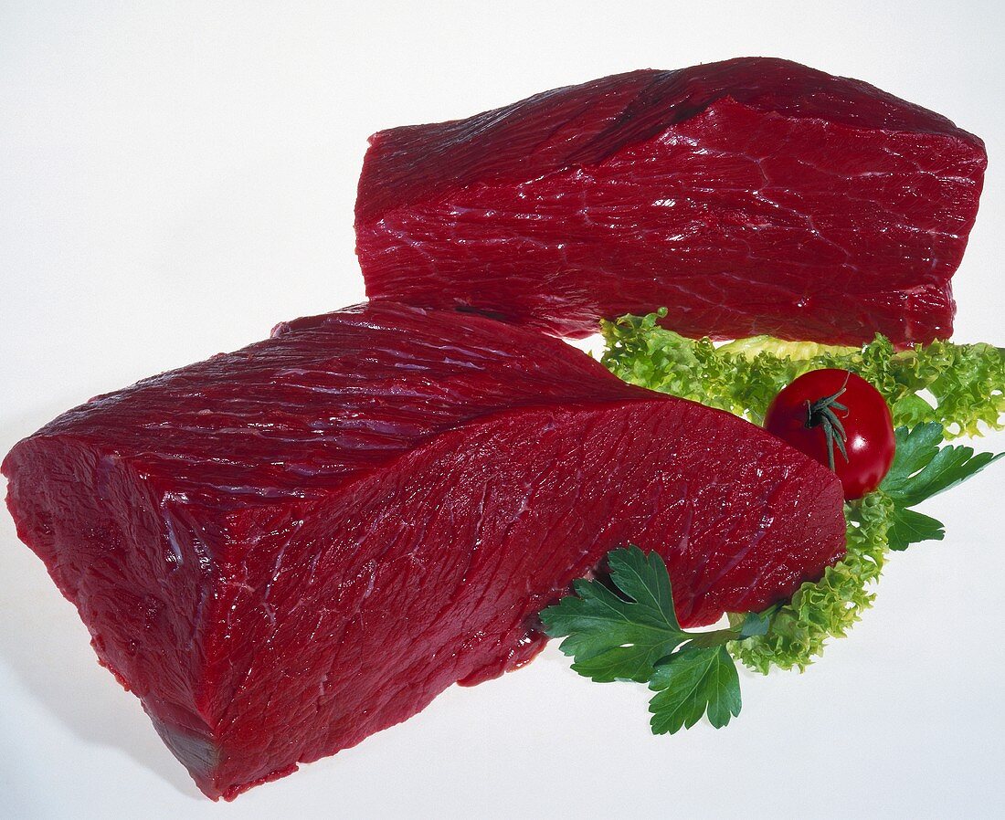 Two pieces of raw beef with salad