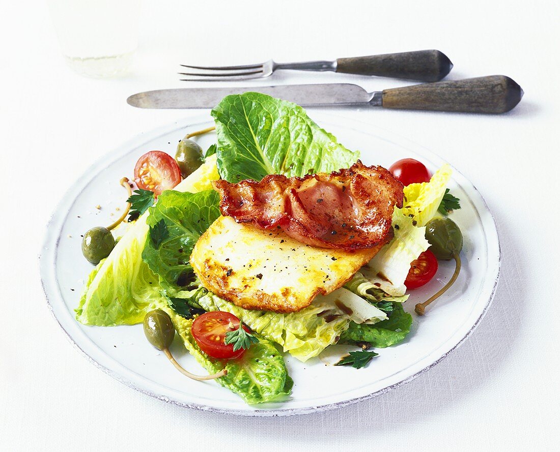 Small salad with capers, fried egg and bacon