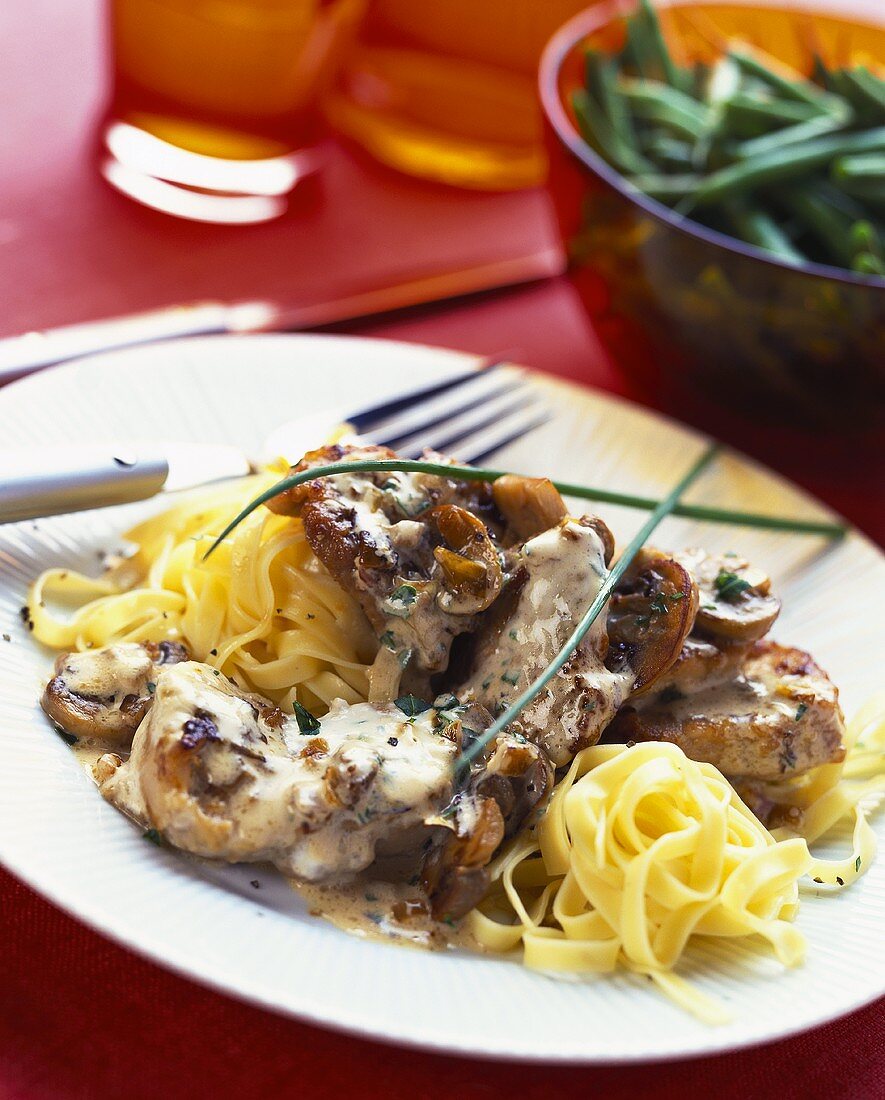 Pork with creamed mushroom sauce on ribbon pasta