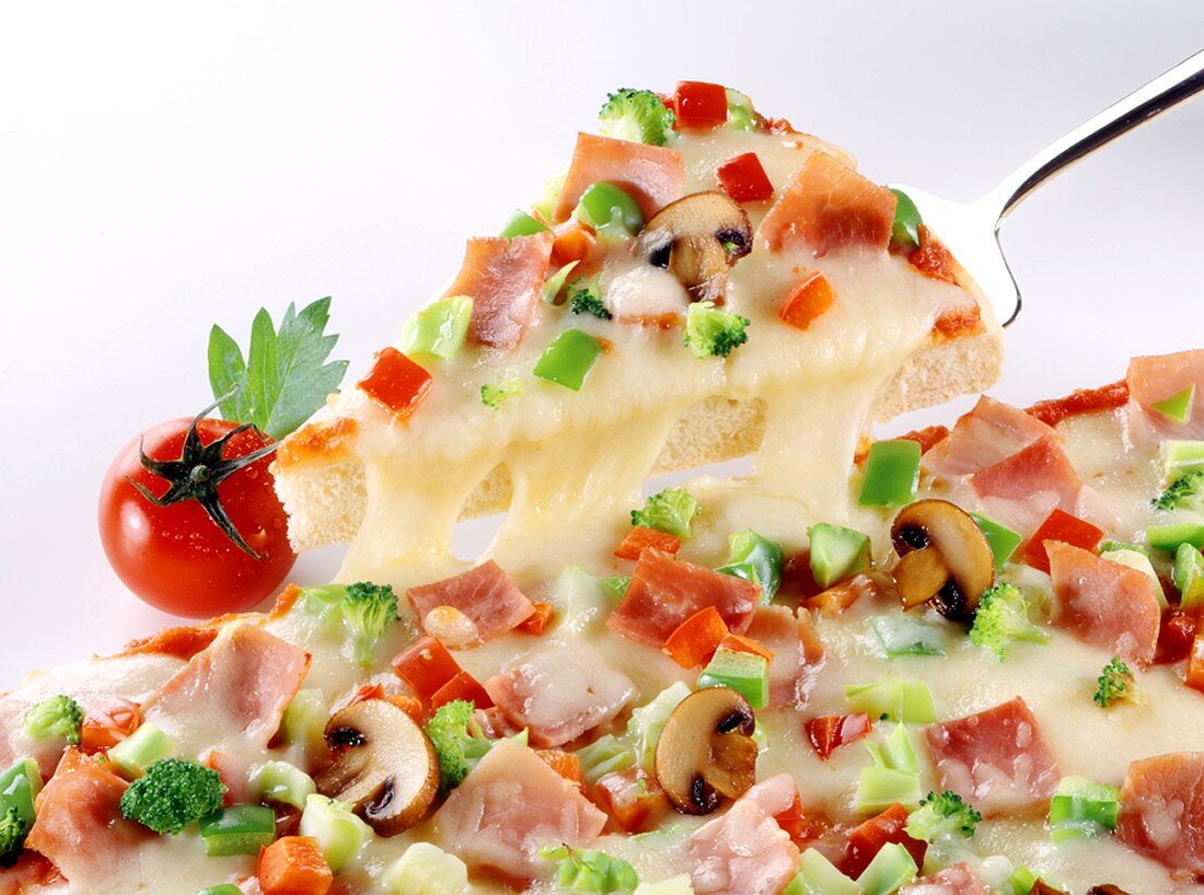 Stück Pizza mit Gemüse, Pilzen, Schinken, Käse auf Pizzaheber