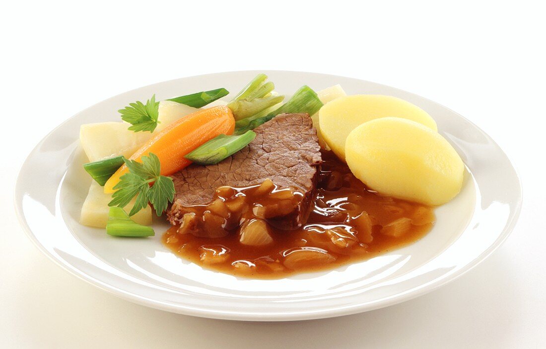 Beef with onion sauce, boiled potatoes and vegetables