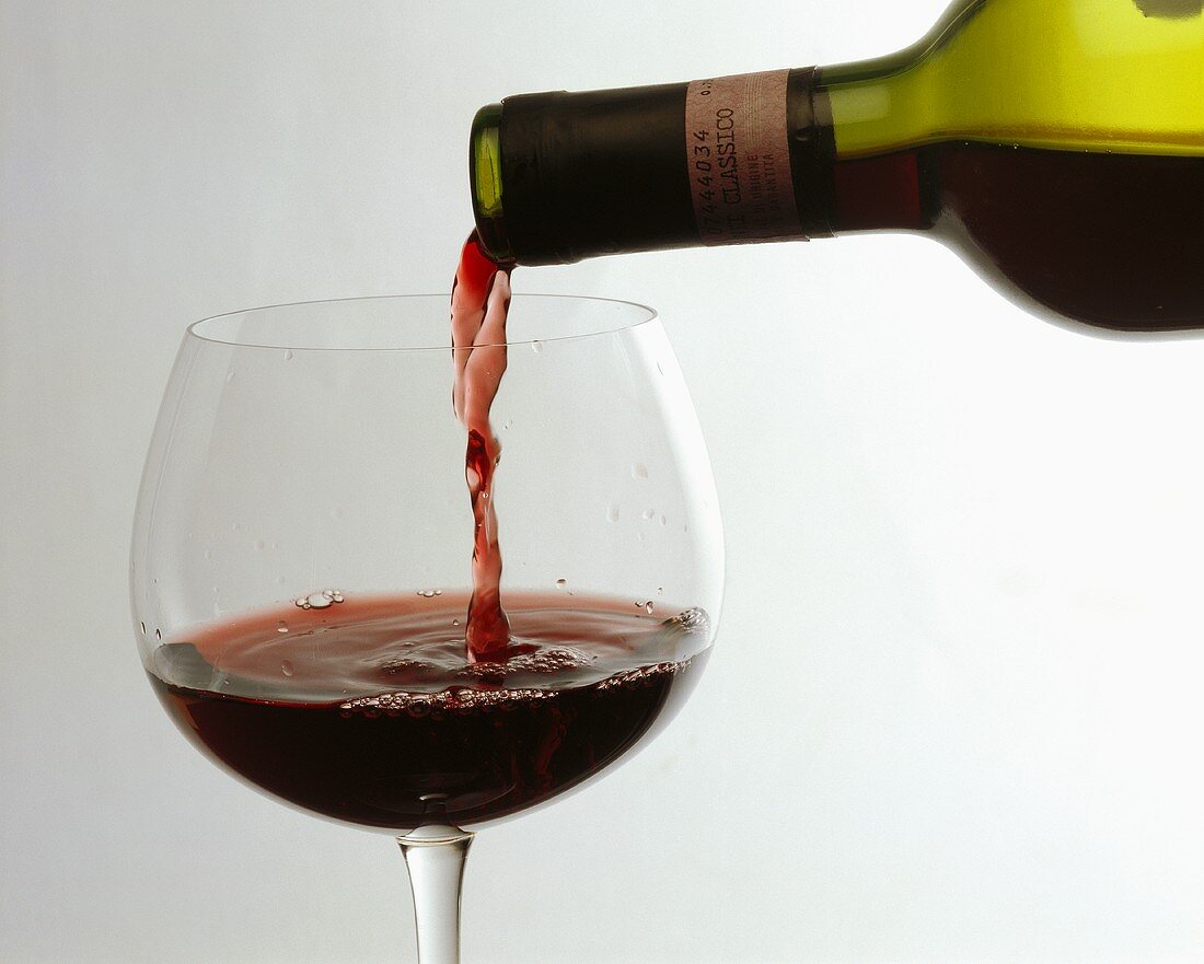 Chianti Classico wird in ein Rotweinglas eingeschenkt