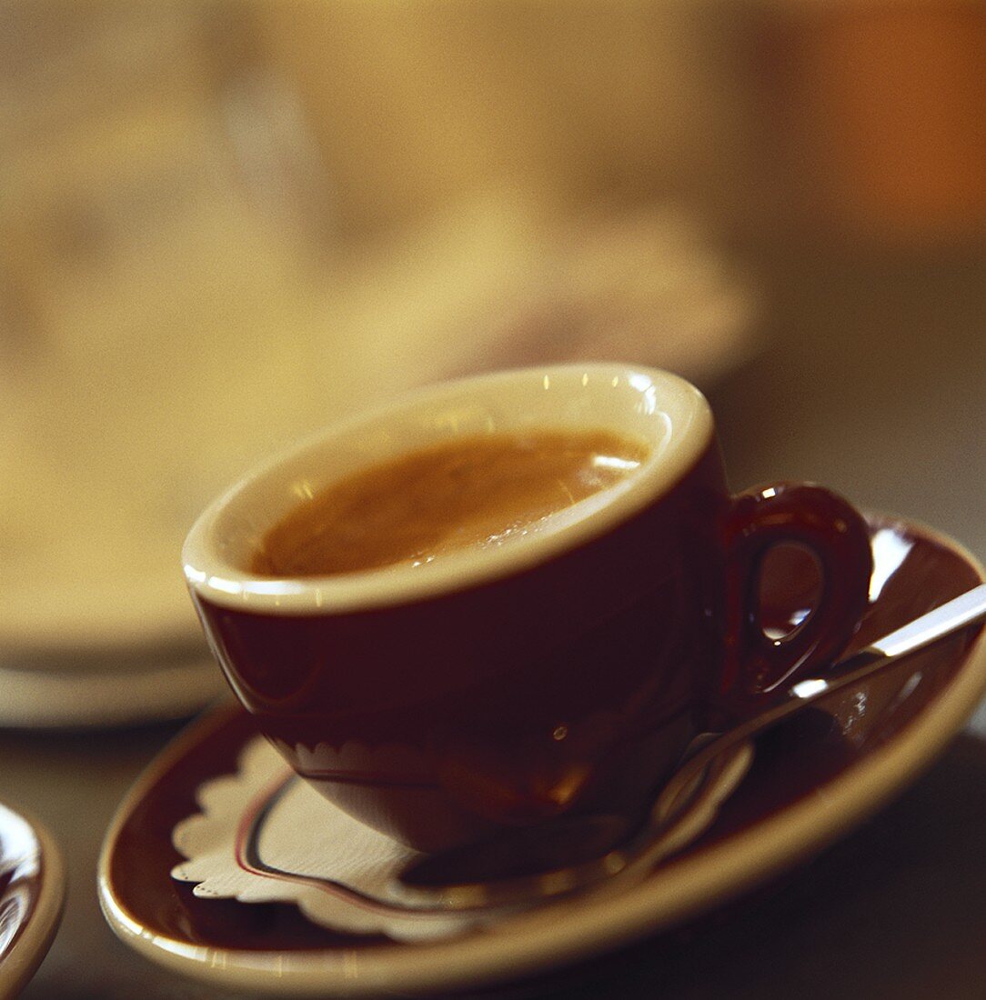 Eine Tasse Espresso mit Löffel auf Untertasse