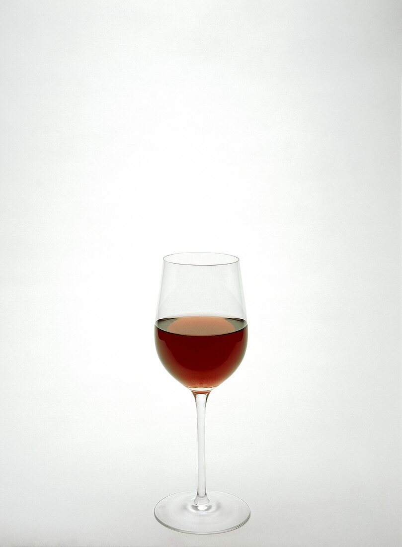 A filled tall red wine glass