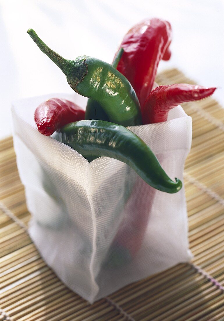Red and green chili peppers in a fabric container