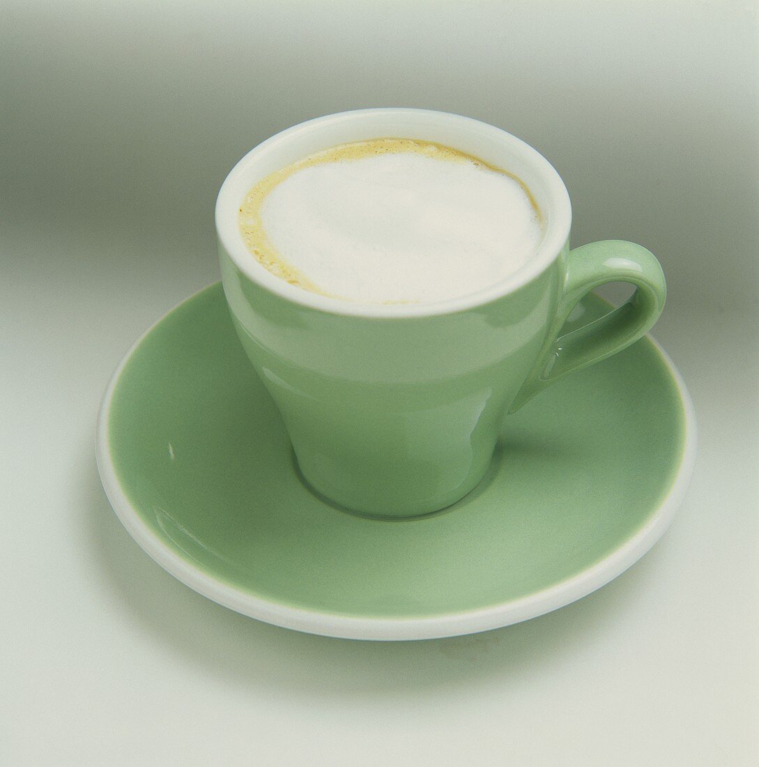 Eine grüne Tasse mit Cappuccino