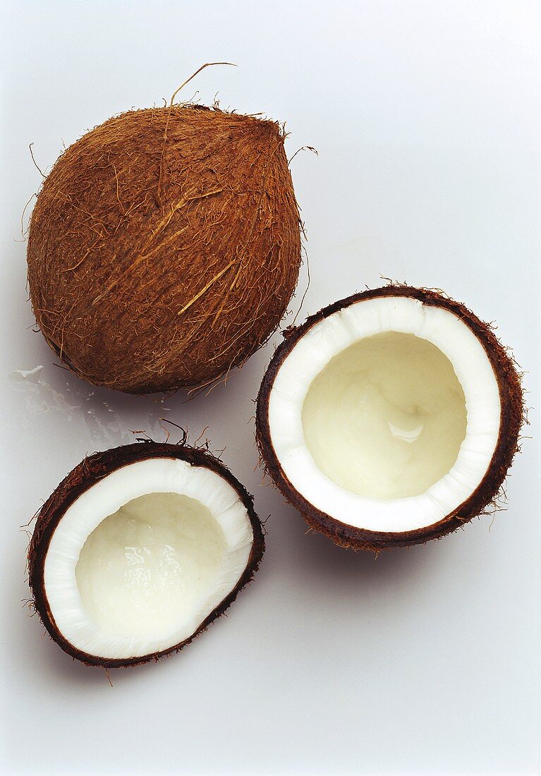 A whole coconut and two coconut halves