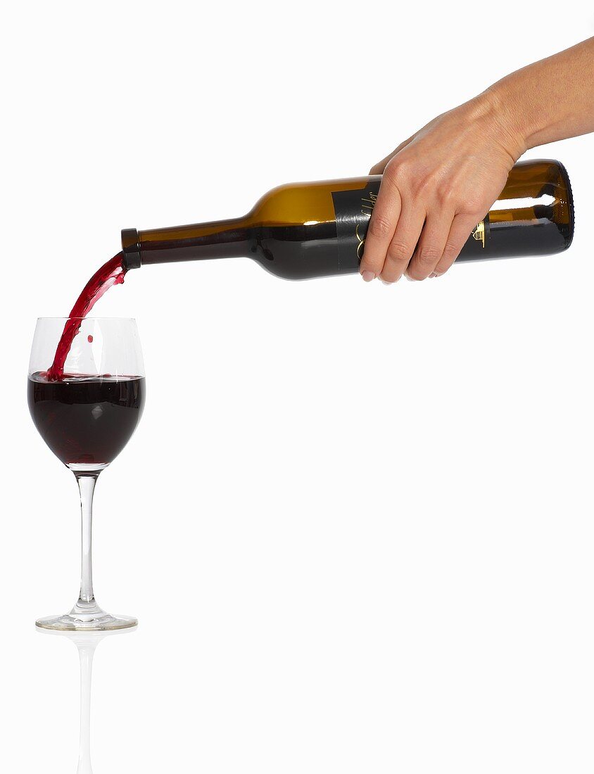 Woman's hand pouring red wine