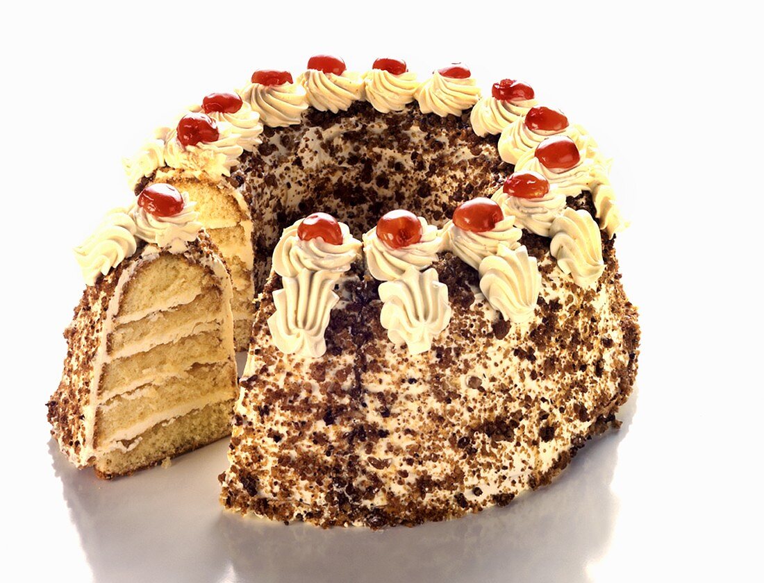 Cream sponge cake with chocolate sprinkles, a piece cut