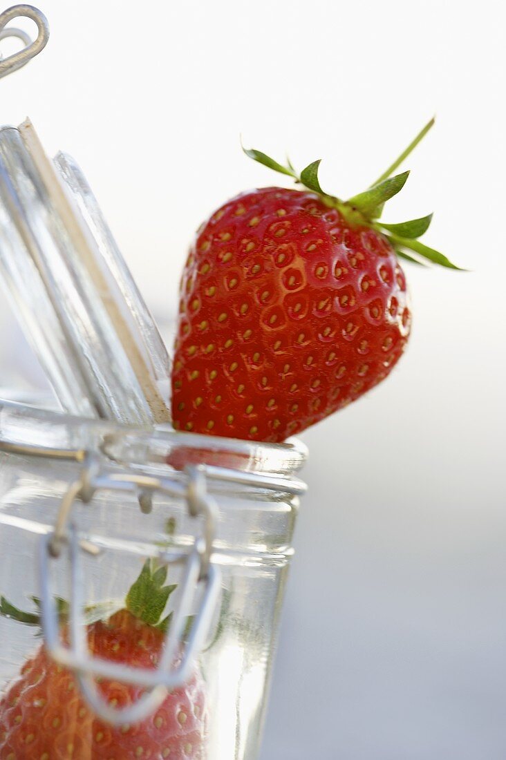 Fresh strawberries and a preserving jar