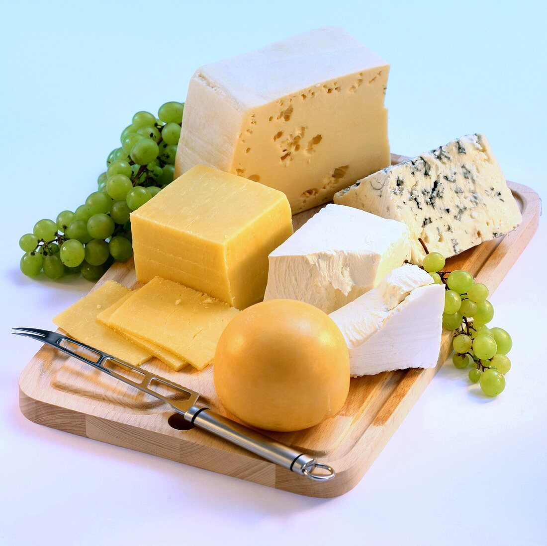 Several types of cheese on a wooden board