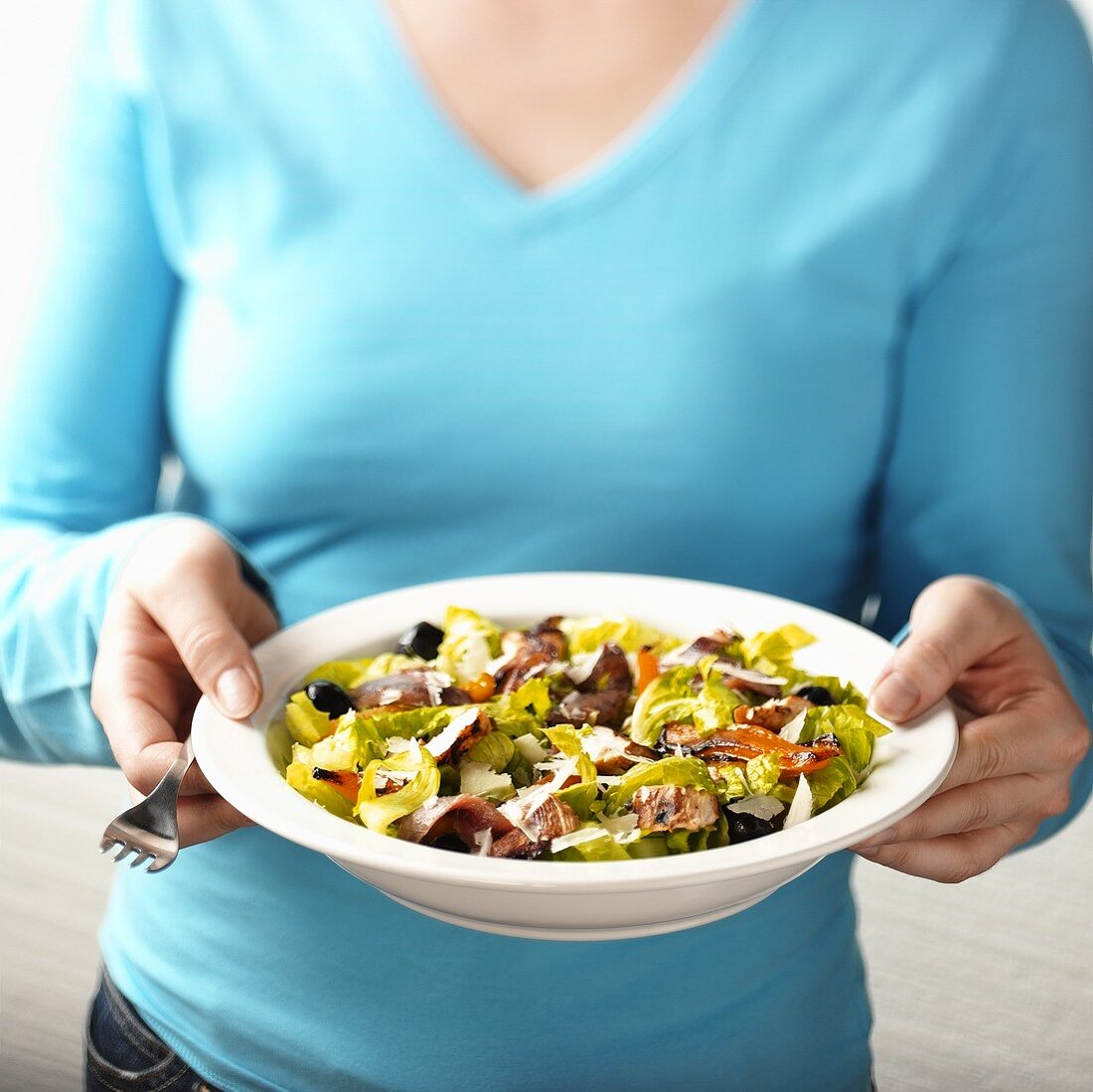 Frau hält einen Salat mit gegrilltem Gemüse