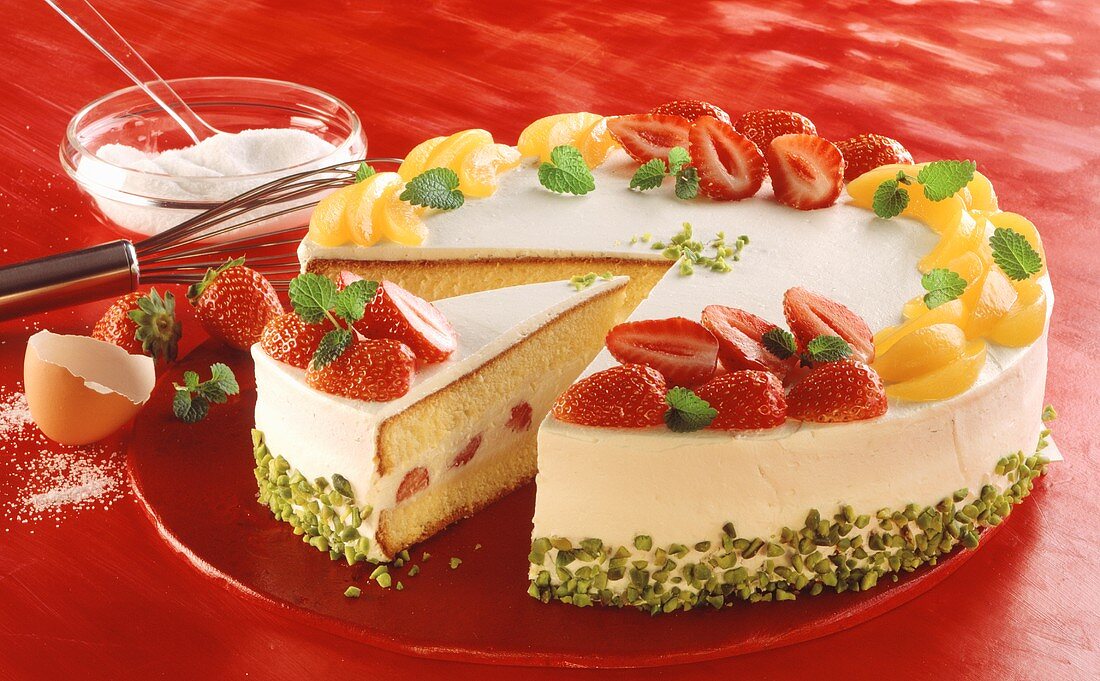 Strawberry cream cake with apricot slices, a piece cut