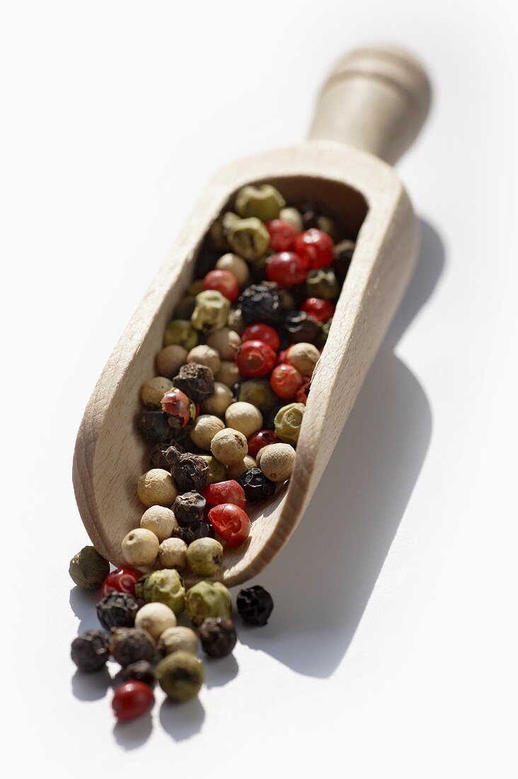 Coloured peppercorns in a wooden scoop