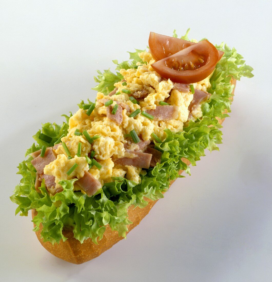 Scrambled egg with ham on a baguette
