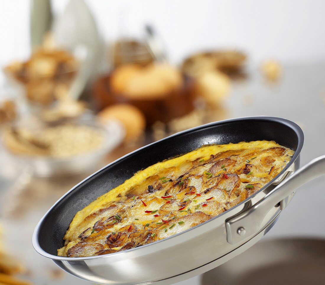 Potato frittata with chili and chives in a frying pan