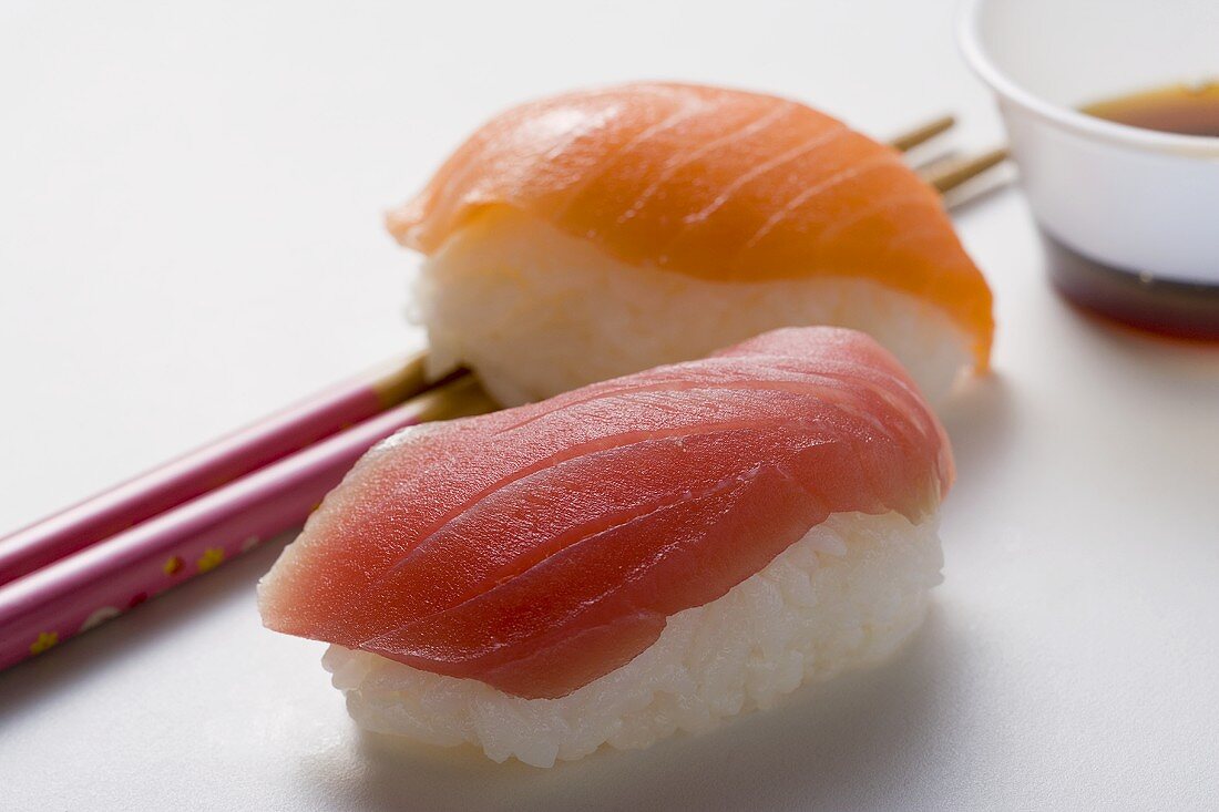 Nigiri sushi with tuna & salmon, chopsticks & soy sauce