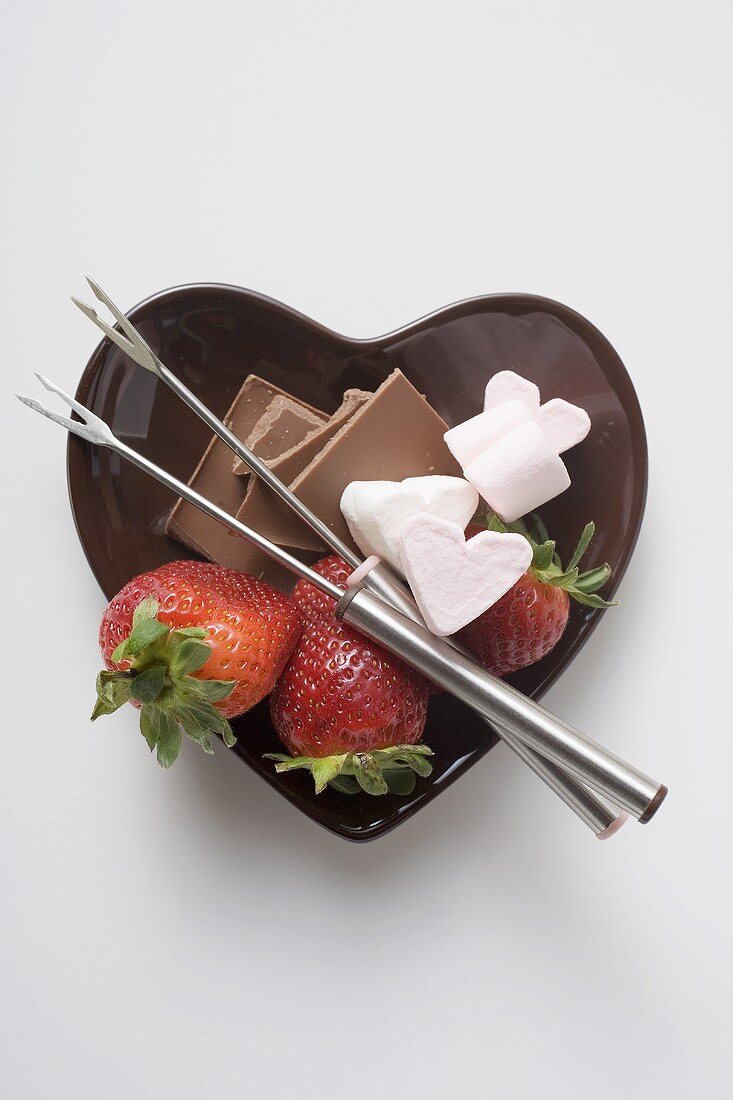 Herzförmiges Schälchen mit Zutaten für Schokoladenfondue