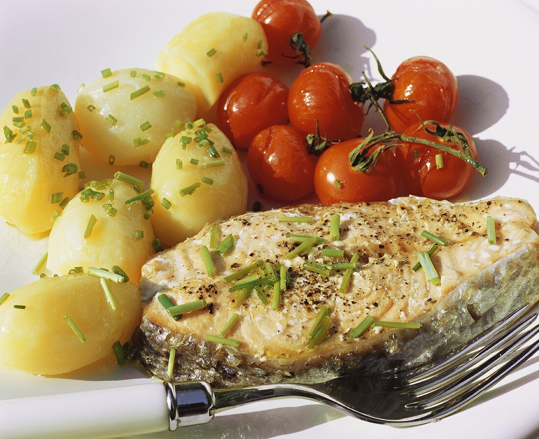 Salmon steak with potatoes and roasted tomatoes