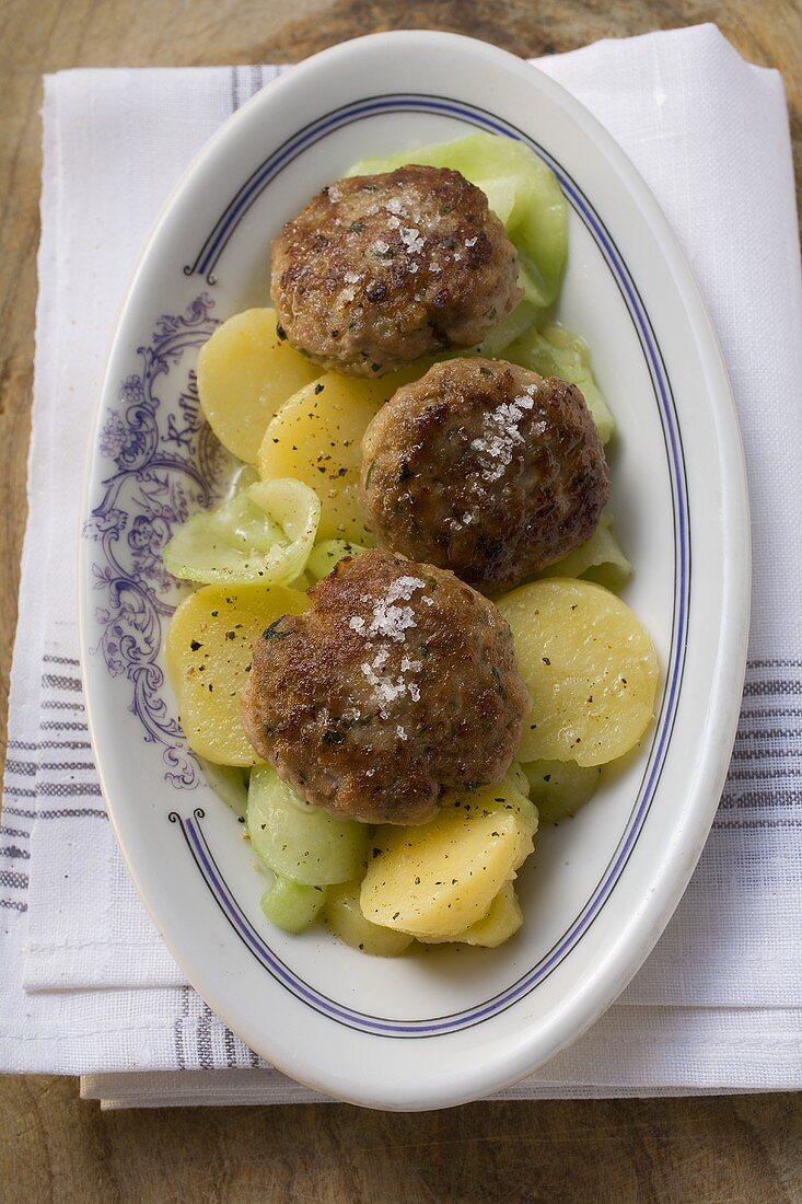 Burgers on potato and cucumber salad