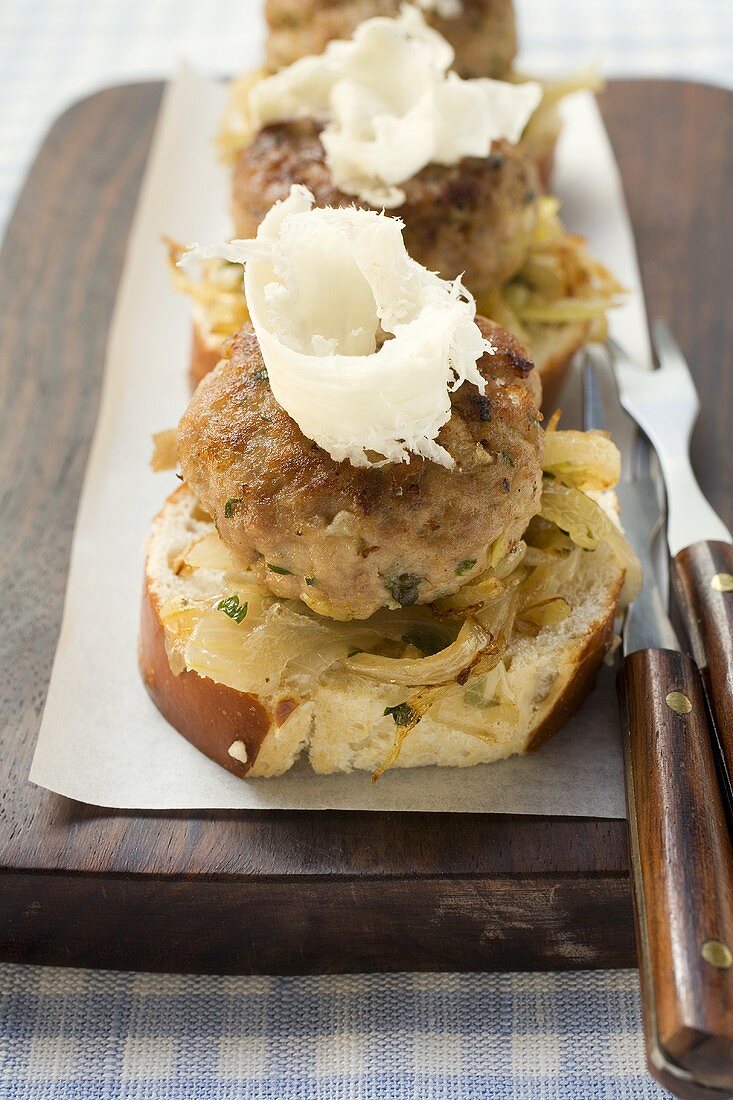 Burgers with onions and horseradish on pretzels