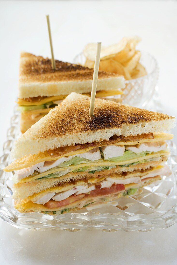 Club sandwiches with chicken breast, crisps behind