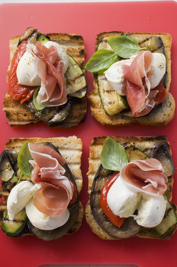 Gegrillte Brotscheiben mit Gemüse, Parmaschinken & Mozzarella