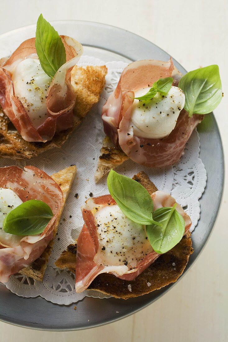 Crostini mit Parmaschinken, Mozzarella und Basilikum