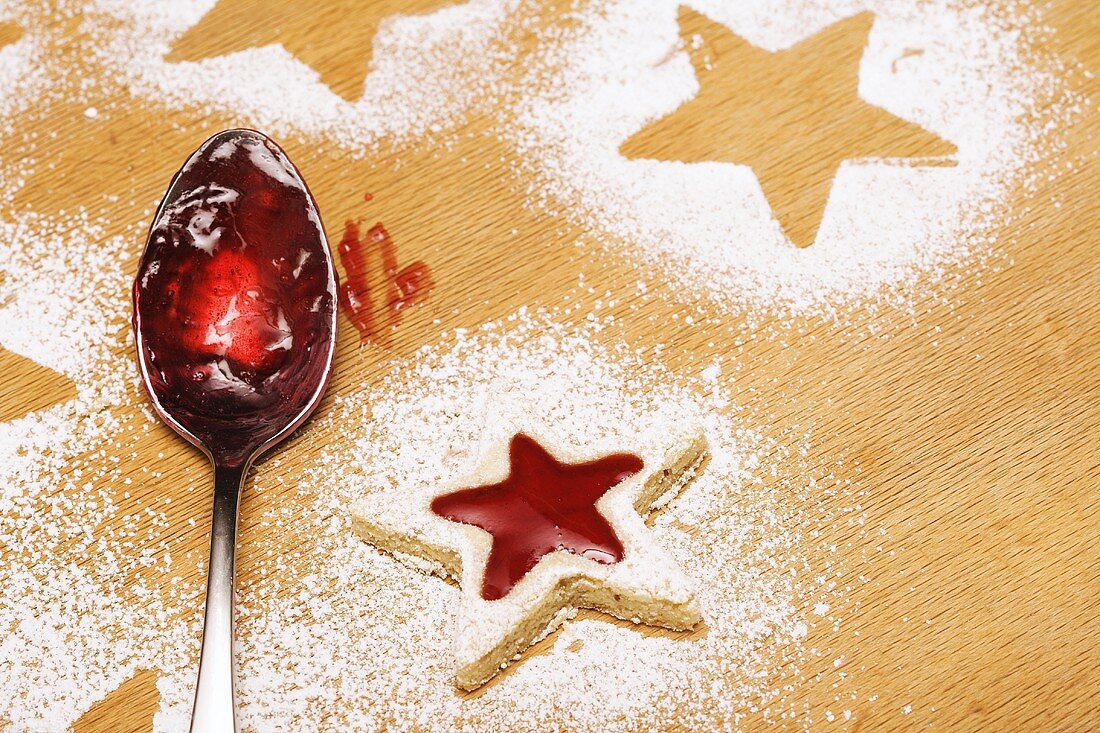 Star-shaped jam biscuit and spoon with jam
